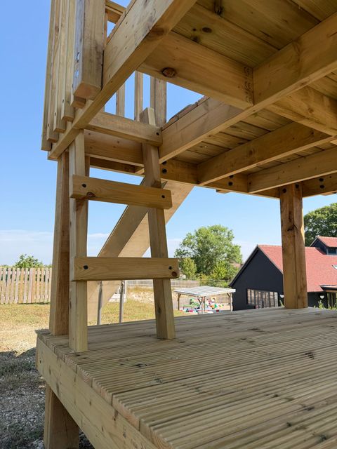 Detail of the underside of a platform, showing the timber joists, bracing and ladder rungs of the frame.