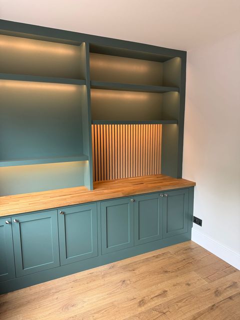 The cupboards from the other end of the room, showing the depth of the shelving and the run of shaker doors.